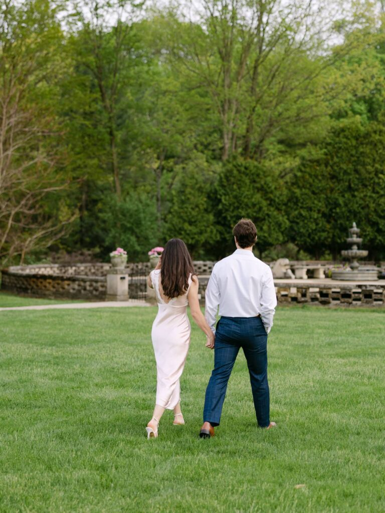 Holding hands walking on the grounds at The felt Mansion