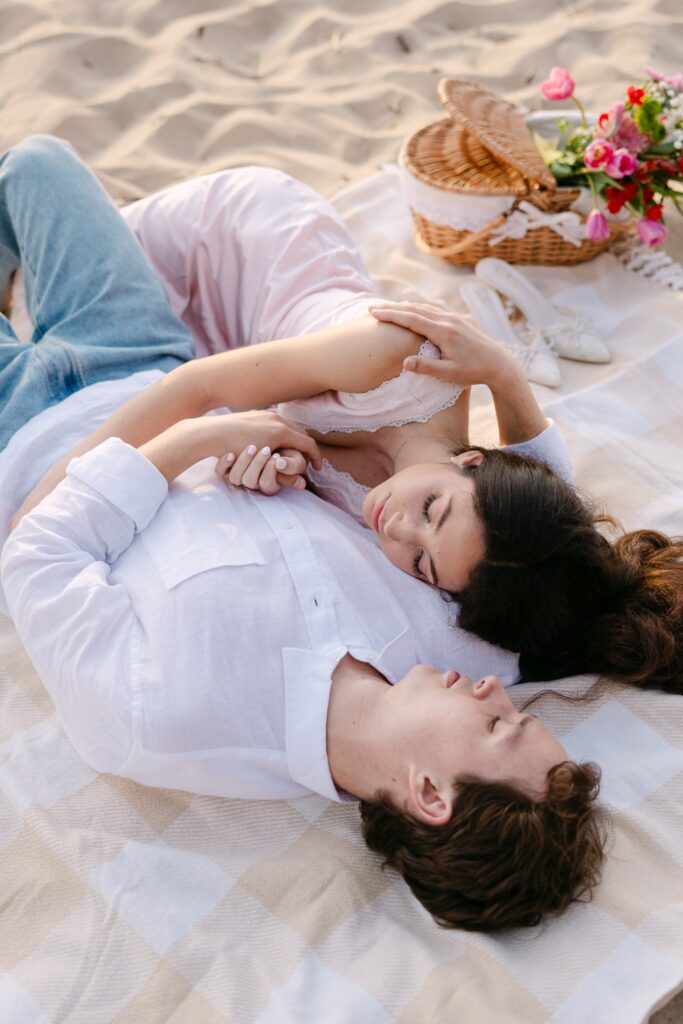 couple cuddling on lake michigan during their engagement session