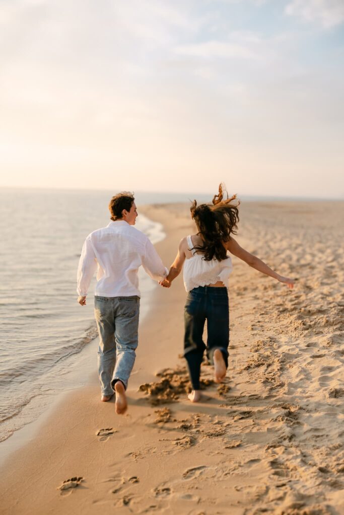 couple running down the beach during their engagement session