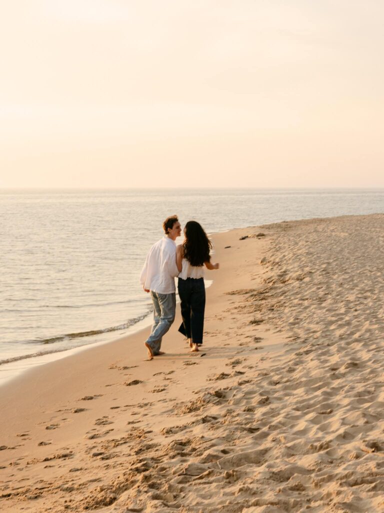 engagement photo couple laughing barfoot and running in the sand