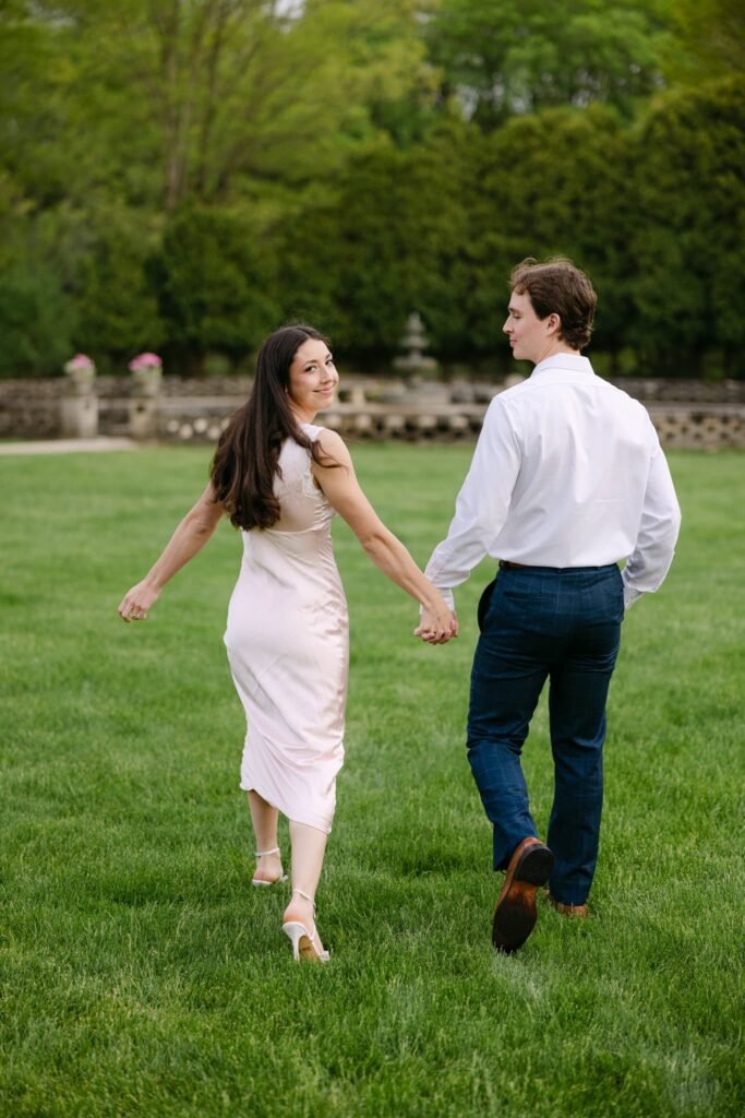 Francesca and Ben Holding hands walking on the grounds at The felt Mansion