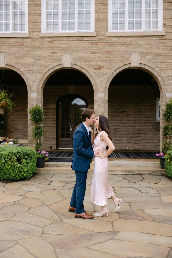 Francesca and ben kissing in front of the Felt Mansion