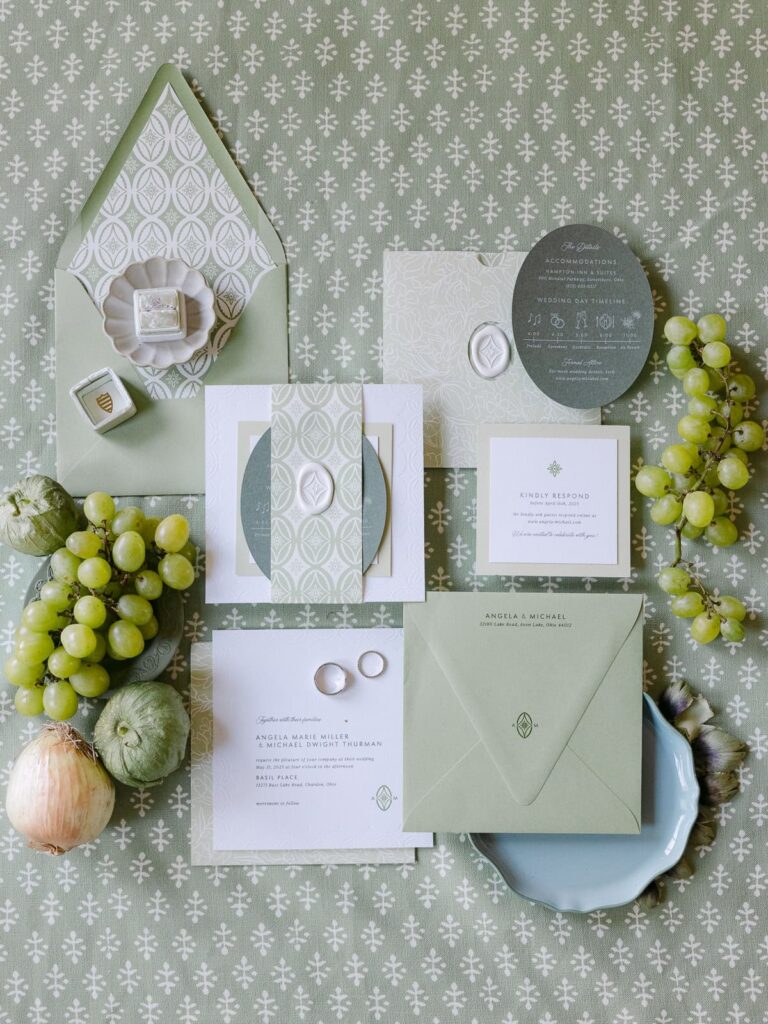 wedding invitation flat lay with onions grapes and artichoke 
