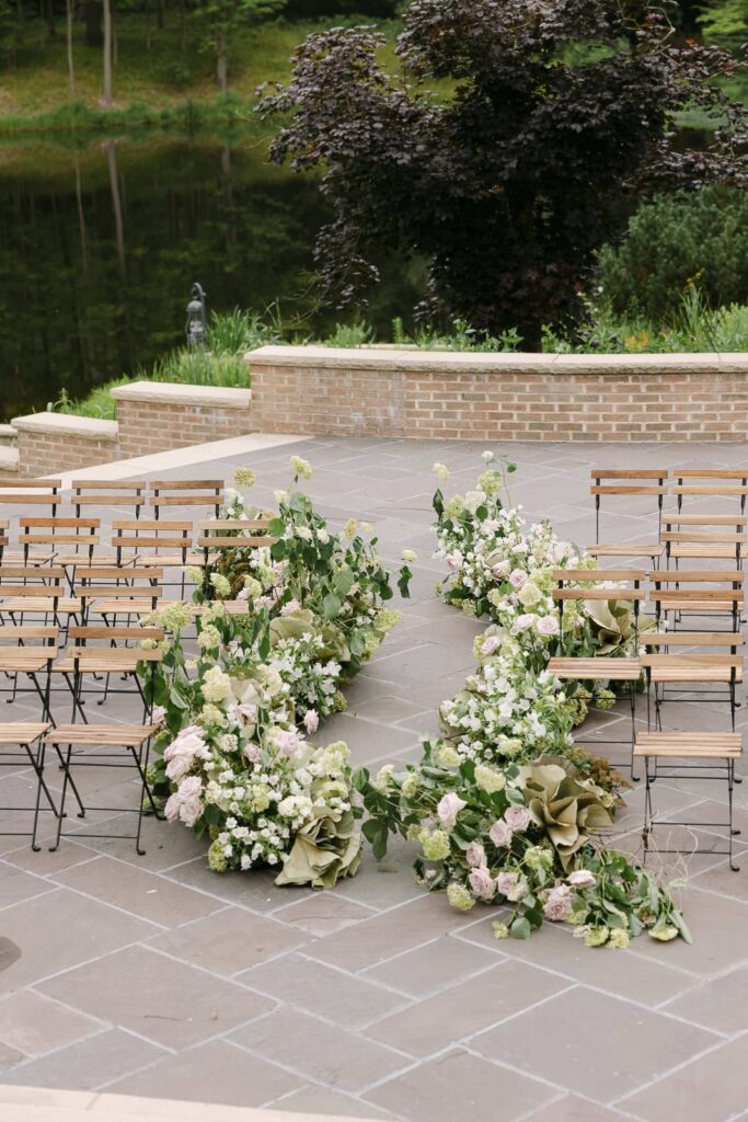 Outdoor wedding ceremony by the pond at basil Place in Ohio featuring floral meadow captured by michigan wedding photographer veil of Grace photography