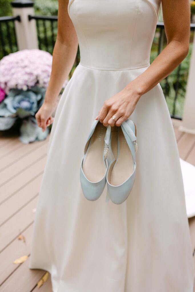 bride holding her shoes before putting them on